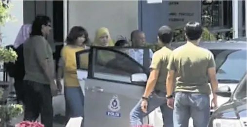  ??  ?? SUSPECT: A woman, fourth left, under arrest, is escorted by Malaysian officials to a car in Kuala Lumpur yesterday