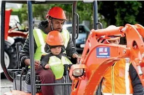  ?? Photo: ROBYN EDIE/STUFF ?? Kamal Singh with his son Lucas Sullivan having a go on the mini digger at Hire & Go, run by Irwin Motors, supervised by Blair Irwin (obscured).