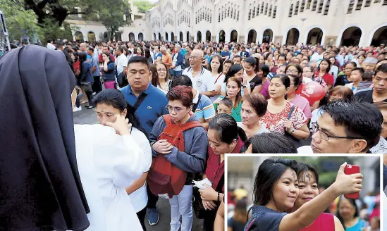  ?? EDD GUMBAN, AP ?? A nun daubs ash on the forehead of a devotee during the observance of Ash Wednesday, which marks the start of Lent, at the Redemptori­st Church in Baclaran, Parañaque yesterday. Inset shows two women taking selfies after the Ash Wednesday rites.