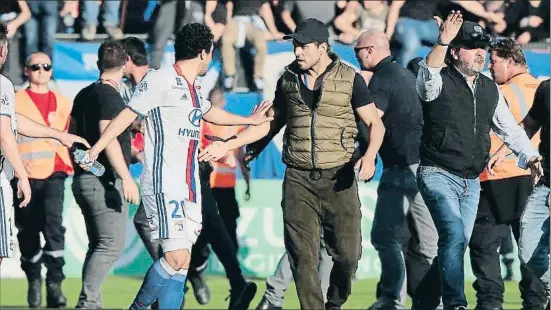  ?? PASCAL POCHARD-CASABIANCA / AFP ?? El brasiler Rafael da Silva, de l’Olympique, s’enfronta a un radical del Bastia en el descans del partit, ahir