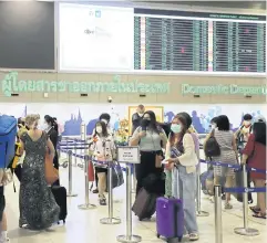  ?? APICHIT JINAKUL ?? Travellers queue to check in with carriers at Don Mueang airport during the Songkran holiday last year.