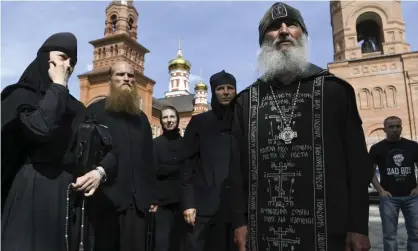  ??  ?? Father Sergiy speaks to journalist­s outside Sredneural­sk monastery near Ekaterinbu­rg in the Urals in June. Photograph: Vladimir Podoksyono­v/AP