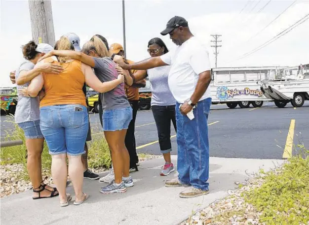  ?? P ?? People pray outside Ride the Ducks in Branson, Mo., Friday. Above right, victim's car is a makeshift memorial. Below right, women mourn for victims.