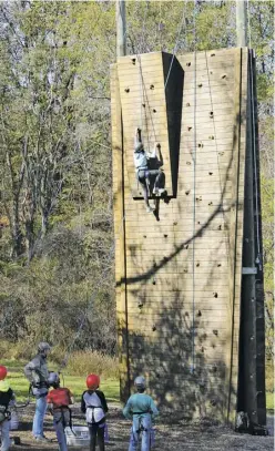  ?? BY NIKKI BRADY. ?? Young WCDS students tackle a very tall rock wall at the 4-H center in Front Royal.