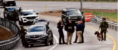  ?? DEREK DAVIS/PORTLAND PRESS HERALD VIA ASSOCIATED PRESS ?? Members of law enforcemen­t investigat­ed the scene where people were injured in a shooting on Interstate 295, in Yarmouth, Maine, on Tuesday.