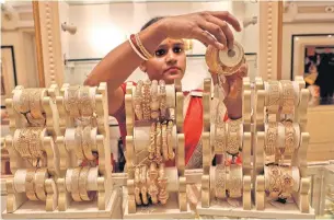  ?? REUTERS ?? A saleswoman shows gold bangles to a customer at a jewellery showroom in Kolkata, India.