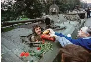  ?? Czarek Sokolowski / Associated Press 1991 ?? Muscovites hand bread, sausages and flowers to a tank driver who helped stop the failed coup in 1991.