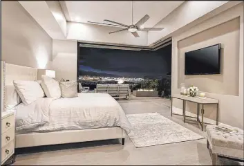  ??  ?? The master bedroom opens to a balcony with a fire feature and views of the Strip.