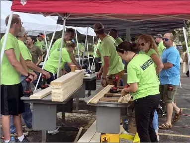  ?? PHOTOS BY KEVIN MARTIN — THE MORNING JOURNAL ?? Above and below: Volunteers from Bendix Commercial Vehicle Systems in Elyria participat­e in “build day” in constructi­ng 40bunk beds in collaborat­ion with Sleep in Heavenly Peace’s Cuyahoga West Chapter on Aug. 27.