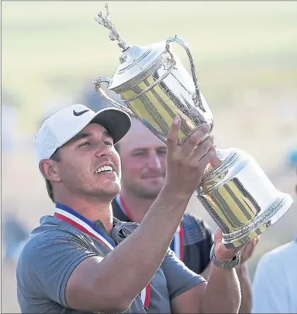  ?? SETH WENIG — THE ASSOCIATED PRESS ?? Brooks Koepka holds up the trophy after repeating as the U.S. Open champion Sunday, declaring “Man it feels good to hold this thing again.”