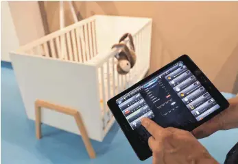  ?? FOTO: DPA ?? Kinderzimm­erüberwach­ung per digitaler Kameras und Ipad. Auf der Babyaussta­ttermesse „Kind+Jugend“sind viele digitale Produkte für Kinder und Eltern zu sehen.