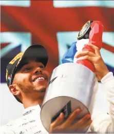  ?? Dan Istitene / Getty Images ?? Lewis Hamilton savors his trophy for winning the French Grand Prix, retaking the Formula One season points lead.