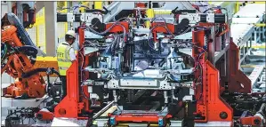  ??  ?? A worker checks the riveting point at a production line of Chery Jaguar Land Rover.