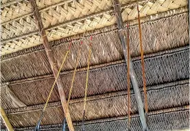  ??  ?? Hand-made arrows to hunt local paca (rodents) are stabbed into thatched-roofs for storage.