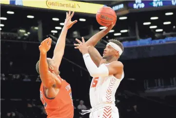  ?? KATHY WILLENS/ASSOCIATED PRESS ?? New Mexico’s Carlton Bragg Jr., left, shoots over Auburn’s Austin Wiley during the first half of their game Monday night. Bragg scored four points in the game.