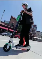  ?? MIKE DE SISTI / MILWAUKEE JOURNAL SENTINEL ?? Steven Johnson of Milwaukee takes a ride on a Lime scooter on South Second Street in Milwaukee.
