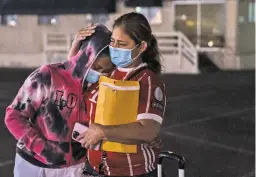  ?? ARIANA DREHSLER NEW YORK TIMES ?? Maria Ana Mendez hugs her daughter Cindy, 16, outside the San Diego Convention Center after an emotional reunion Wednesday. When Maria Ana Mendez left Honduras a decade ago to earn money in the United States, Cindy was still in pigtails and playing with dolls.