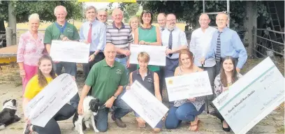  ??  ?? ●● The sheep dog trial team presenting money to charities this week from last year’s event