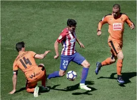  ?? — AFP ?? Atletico Madrid’s Nicolas Gaitan (centre) looks to get past Eibar’s Pedro Leon (right) and Daniel Garcia Carrillo during their match in Madrid on Saturday. Atletico won 1-0.