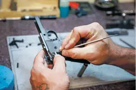  ??  ?? Rick Kennedy, a Santa Fe County gunsmith, makes the final adjustment­s to a customer’s gun at MAGS Indoor Shooting Range in Moriarty.