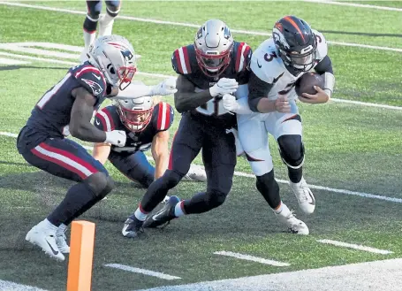  ?? Andy Cross, The Denver Post ?? Broncos quarterbac­k Drew Lock gets knocked out of bounds by Patriots free safety Devin McCourty in the third quarter on Sunday. Defenive back Jonathan Jones, left, and defensive end Chase Winovich, back, were in on the play.