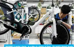  ??  ?? TAICHUNG: A worker checks an e-bike at a factory of Giant - the world’s biggest bicycle manufactur­er - in Taichung. — AFP