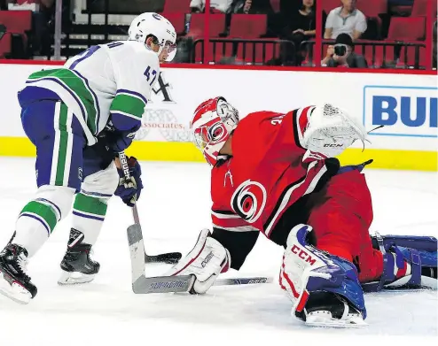  ?? — THE ASSOCIATED PRESS ?? Carolina Hurricanes goaltender Curtis McElhinney tries to block the shot of Vancouver Canucks’ Sven Baertschi during the first period on Tuesday in Raleigh, N.C. The Hurricanes took the Canucks 5-3.