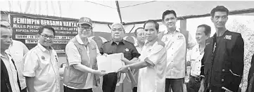  ??  ?? Liew (third left) receiving the applicatio­n forms of ex-PBS members from Sazalye Donol, witnessed by others during the meet the people session at Kampung Rita last Sunday.