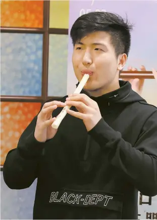  ??  ?? Wei Sijun plays a replica bone flute, said to be China’s oldest musical instrument as well as the world’s oldest wind instrument. — Ti Gong