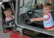  ?? Staff photos by Tom Kelly IV ?? Austin Turley, 1, of West Chester, takes the wheel of a First West Chester Fire Company fire engine during the restaurant festival.