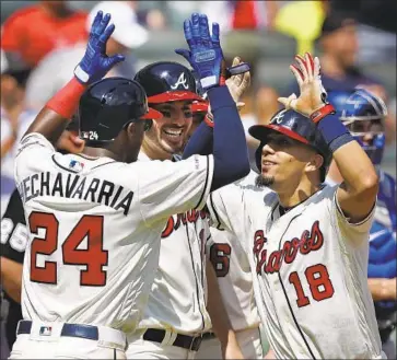  ?? Curtis Compton Associated Press ?? THE BRAVES’ Rafael Ortega, right, is greeted by Adeiny Hechavarri­a and Matt Joyce after hitting a grand slam in the sixth inning against reliever Dustin May and the Dodgers. The Braves held on for the 5-3 victory.