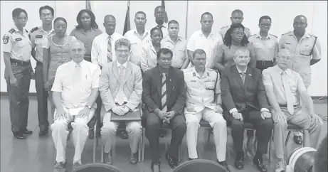  ??  ?? Seated, from second, at left, are British High Commission­er to Guyana Greg Quinn, Public Security Minister Khemraj Ramjattan, acting Police Commission­er David Ramnarine and UK security expert Lt Col (rtd) Russell Combe, with the two trainers and...