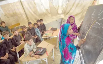  ?? — AFP ?? Children attend a class at a tent school in Tanjai Cheena, a village in Swat Valley.