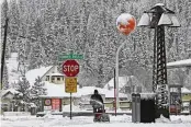  ?? ANDY BARRON / AP ?? Juan Manuel plows the snow off a sidewalk in downtown Truckee, Calif., on Friday. A blizzard is forecast to bring up to 10 feet of snow into the Sierra Nevada.