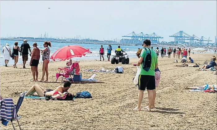  ?? LVE ?? En la playa de València la gente mantuvo ayer las normas de distancia bajo una intensa vigilancia policial; se teme la llegada de turistas de otras provincias