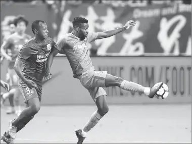  ?? DING TING / XINHUA ?? Cedric Bakambu unleashes a shot for Beijing Guo’an against Shanghai Shenhua on Saturday.