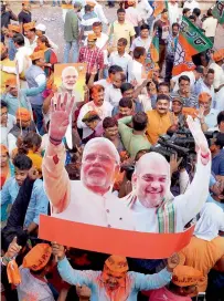  ?? PTI ?? BJP workers carry a cut-out of Modi and Amit Shah as they celebrate the party’s victory, in Bhubaneswa­r. —