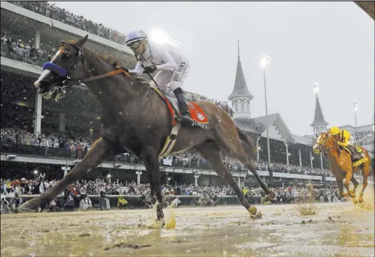  ?? Morry Gash The Associated Press ?? Mike Smith rides Justify to a 2½-length victory Saturday during the 144th running of the Kentucky Derby in Louisville, Ky.