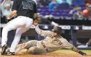  ?? Lynne Sladky / Associated Press ?? San Diego’s Manny Machado scores on an error by Miami catcher Sandy Leon in the eighth inning.