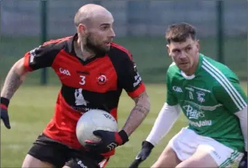  ??  ?? John Staples of Bannow-Ballymitty gives Naomh Eanna captain Peter Travers the slip.