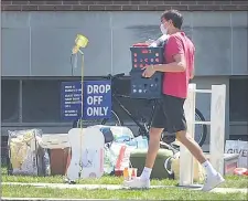  ?? PETE BANNAN — MEDIANEWS GROUP ?? A Villanova student carries his belongings into a dorm on the first of a number of move-in days in August. School officials staggered times to minimize crowds.