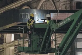  ?? GEMUNU AMARASINGH­E/AP ?? Workers remove the signage at Washington, D.C.’s, Trump Internatio­nal Hotel on Wednesday.