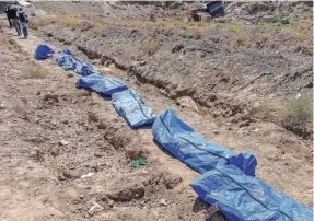  ?? FILIP WARWICK/ARA NETWORK ?? The remains of victims of Islamic State fighters are lined up at a makeshift burial site at the zoo in Raqqa, Syria. Teams have been working to find tens of thousands of missing people.