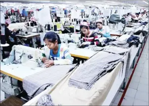  ?? VIREAK MAI ?? Garment workers make clothing at a factory in Kandal province in 2013.