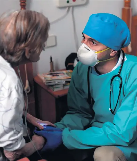  ?? GETTY IMAGES ?? Support: A doctor holds the hands of an elderly and isolated patient