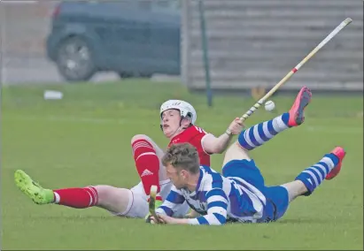  ?? Photograph: Donald Cameron. ?? Kinlochshi­el’s Jordan Fraser and Newtonmore’s Andy MacKintosh on the ground after a tackle during their Artemis Macaulay Cup tie. Kinlochshi­el came out on top by the odd goal in three.