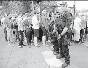  ?? AP/RUI VIEIRA ?? Police watch fans of the Courteener­s, a U.K. rock band, arrive for a concert Saturday at Old Trafford Cricket Ground in Manchester, England. The venue is just a few miles away from Manchester Arena, the site of a bombing during a concert last week.