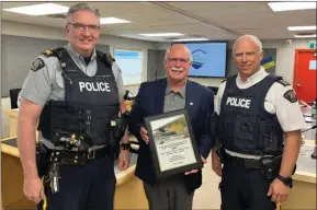  ?? ?? Contribute­d
West Kelowna Mayor Gord Milsom presents a plaque recognizin­g 150 years of service to RCMP Insp. Rob Pikola and Staff Sgt. Duncan Dixon of the West Kelowna detachment.