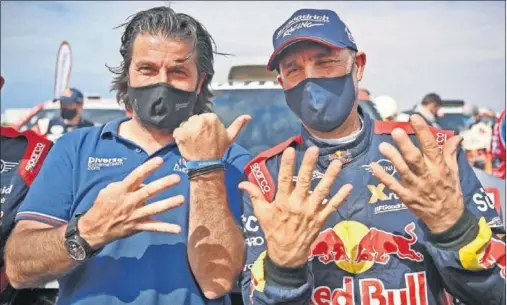  ??  ?? David Castera junto a Peterhanse­l celebra la decimocuar­ta victoria absoluta del piloto francés entre motos y coches.