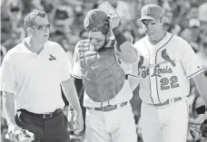  ?? CHARLES REX ARBOGAST/AP ?? Trainer Chris Conroy and manager Mike Matheny flank Yadier Molina, expected to miss four weeks.